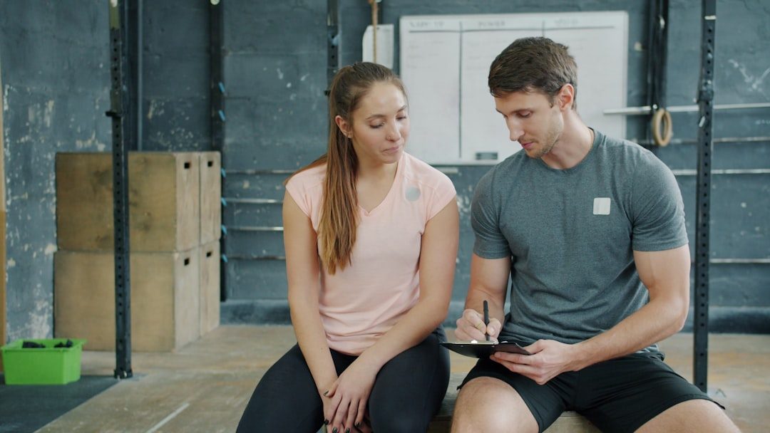 Trainer and client discussing workout plan in gym.