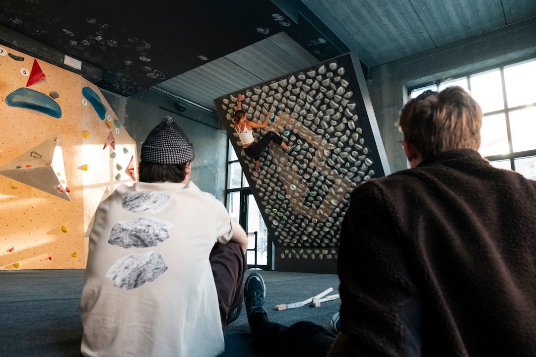 People watching climber on indoor climbing wall